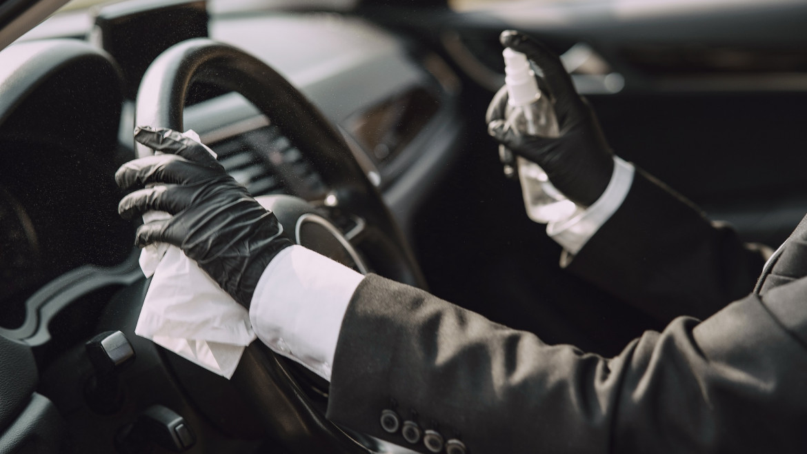 Businesswoman in a black mask sitting inside a car