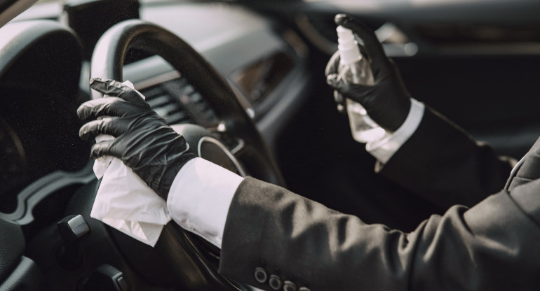 Businesswoman in a black mask sitting inside a car