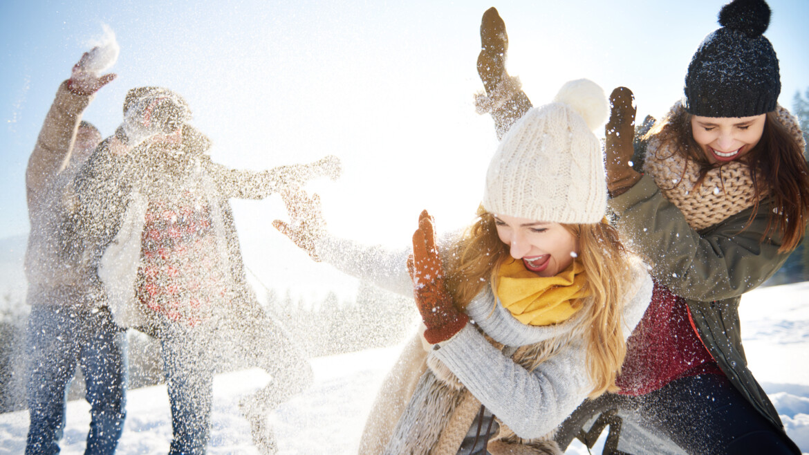 Boys throwing snowballs right on the girls