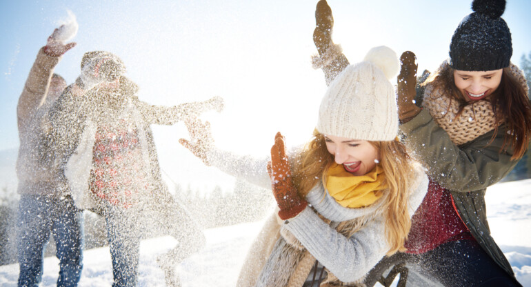 Boys throwing snowballs right on the girls